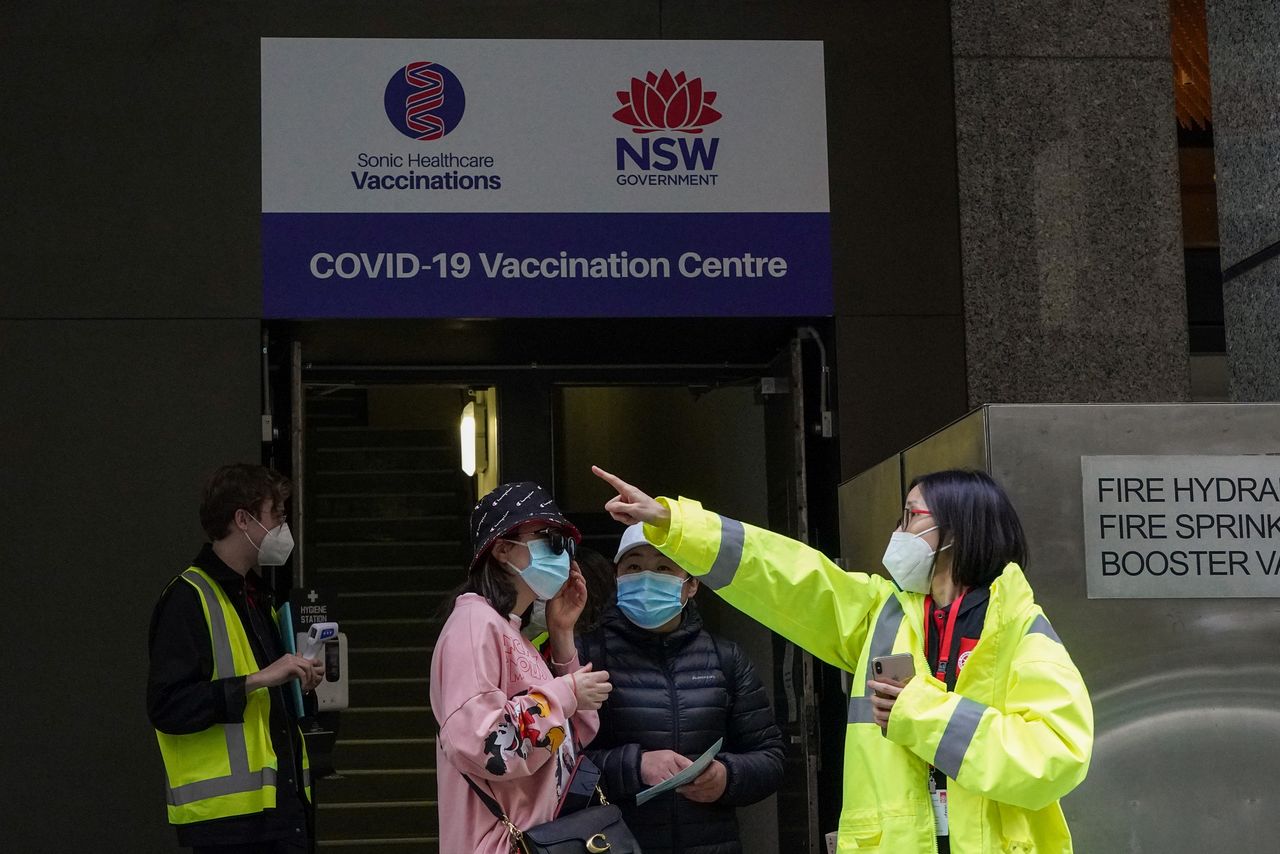 Un miembro del personal habla con la gente en la entrada de un centro de vacunación mientras se mantiene el bloqueo para frenar la propagación de un brote de la enfermedad del coronavirus (COVID-19) en Sidney, Australia, 18 de agosto de 2021. REUTERS/Loren Elliott