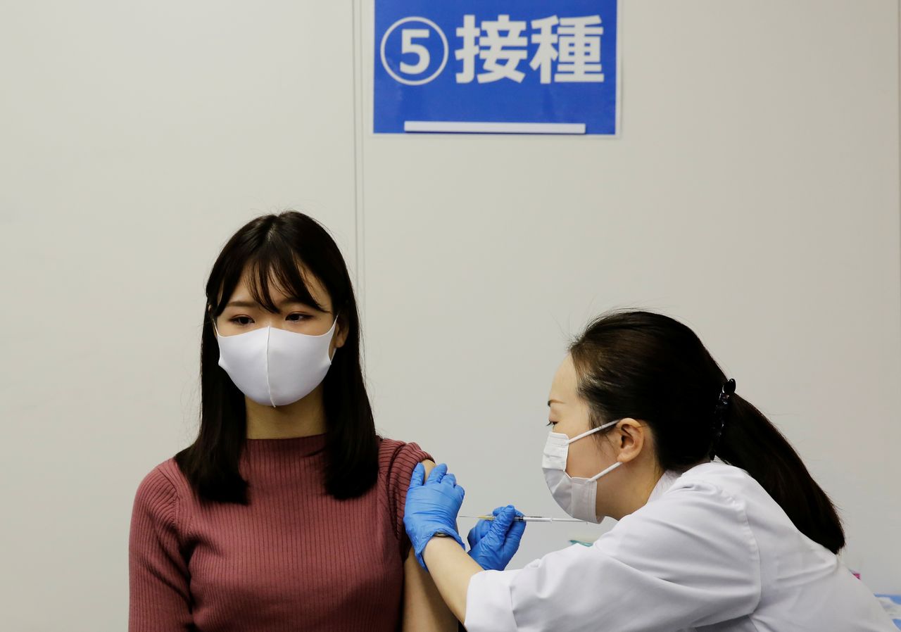 Una empleada de la aerolínea All Nippon Airways (ANA) recibe una dosis de la vacuna de Moderna contra el coronavirus en las instalaciones de la compañía en el aeropuerto de Haneda, Tokio, Japón. 14 junio 2021. REUTERS/Kim Kyung-Hoon