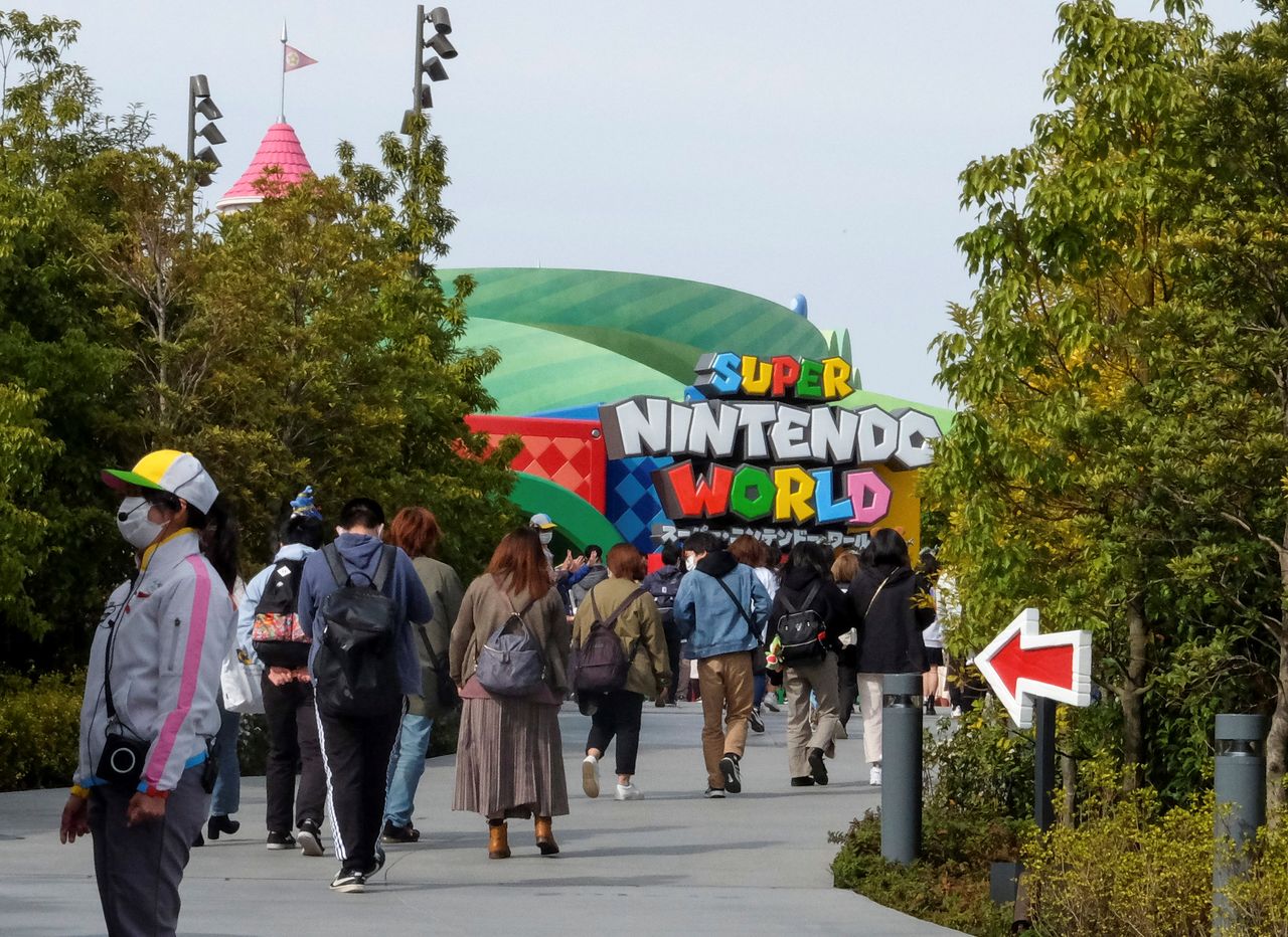 FILE PHOTO: Visitors walk toward to Super Nintendo World, a new attraction area featuring the popular video game character Mario which is set to open to public on March 18, at the Universal Studios Japan theme park in Osaka, western Japan, March 17, 2021. REUTERS/Irene Wang