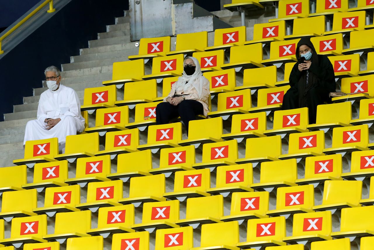 FOTO DE ARCHIVO: Tres personas con mascarilla asisten a un partido de fútbol en un estadio de Riad, Arabia Saudí, el 30 de marzo de 2021. REUTERS/Ahmed Yosri