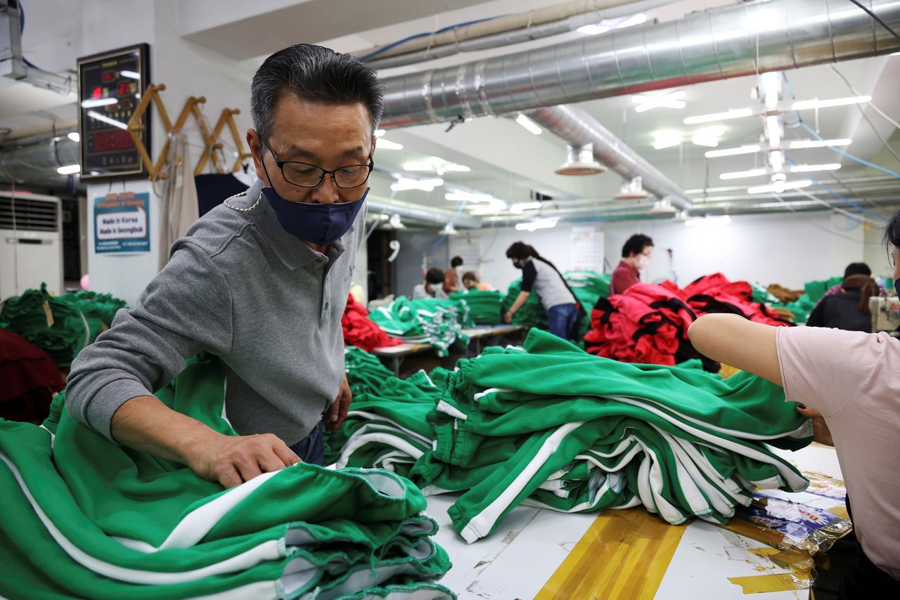 Ko Jong-hyun, de 59 años, propietario de una fábrica de ropa, comprueba la indumentaria recién hecha inspirada en la serie de Netflix "El juego del calamar" en su planta de Seúl, Corea del Sur, el 21 de octubre de 2021. Imagen tomada el 21 de octubre de 2021.  REUTERS/Kim Hong-Ji