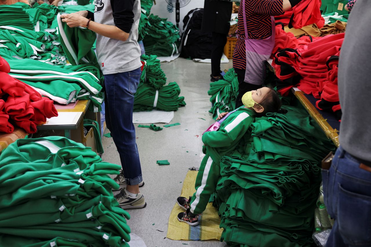 La nieta del propietario de una fábrica de ropa se apoya en la indumentaria inspirada en la serie de Netflix "El juego del calamar" en su planta de Seúl, Corea del Sur, el 21 de octubre de 2021. Imagen tomada el 21 de octubre de 2021.  REUTERS/Kim Hong-Ji