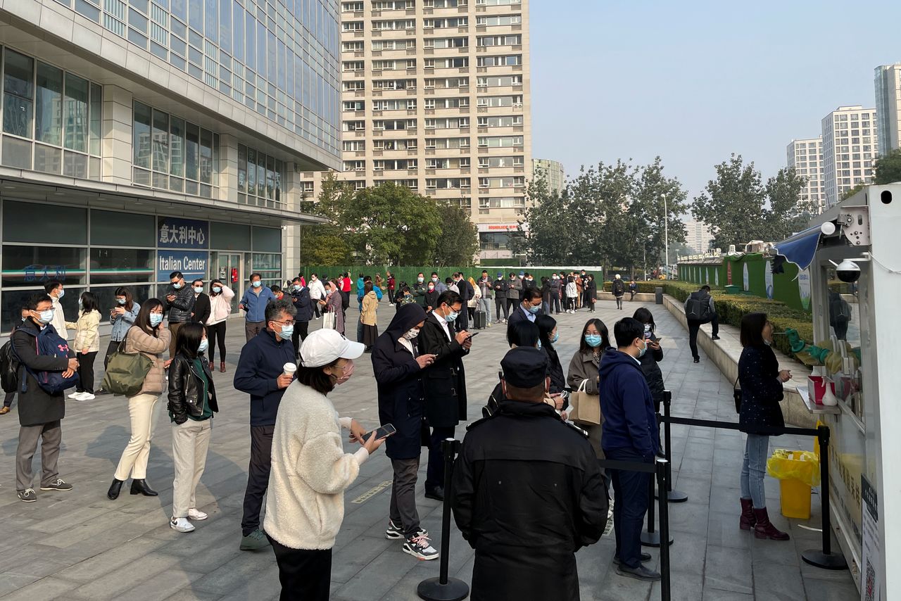 La gente hace cola para hacerse una prueba de ácido nucleico en un puesto en la calle fuera de un centro comercial, a raíz de los nuevos casos de la enfermedad del coronavirus (COVID-19), en Pekín, China, 25 de octubre de 2021. REUTERS/Carlos García Rawlins