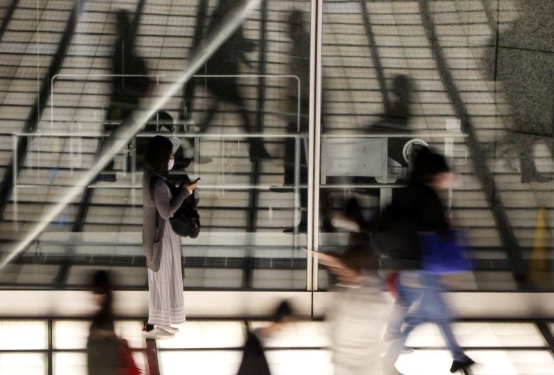 FOTO DE ARCHIVO: Transeúntes con mascarillas caminan por un vestíbulo en Tokio, Japón, el 16 de abril de 2021. REUTERS/Corresponsal