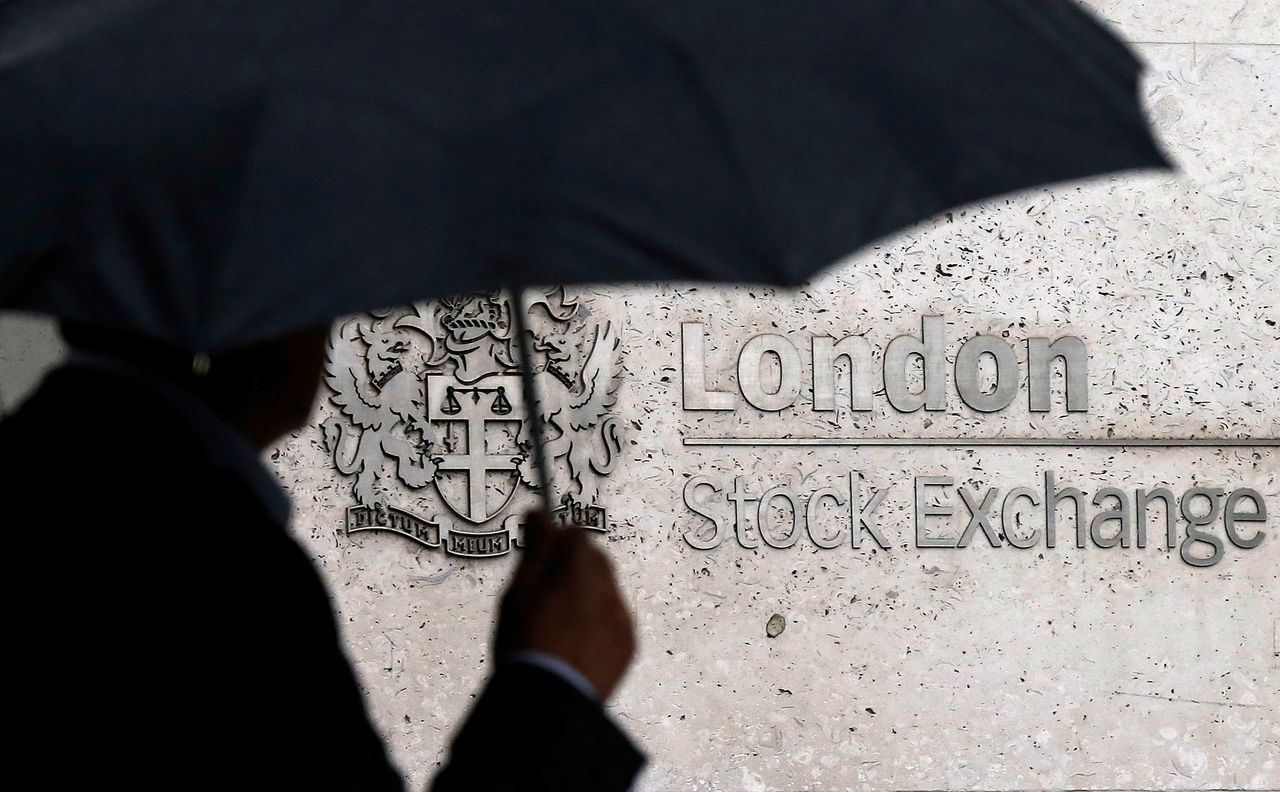 Imagen de archivo de un hombre cubierto con un paraguas mientras camina frente a la Bolsa de Valores de Londres en Londres, Reino Unido. 24 de agosto, 2015. REUTERS/Suzanne Plunkett/Archivo