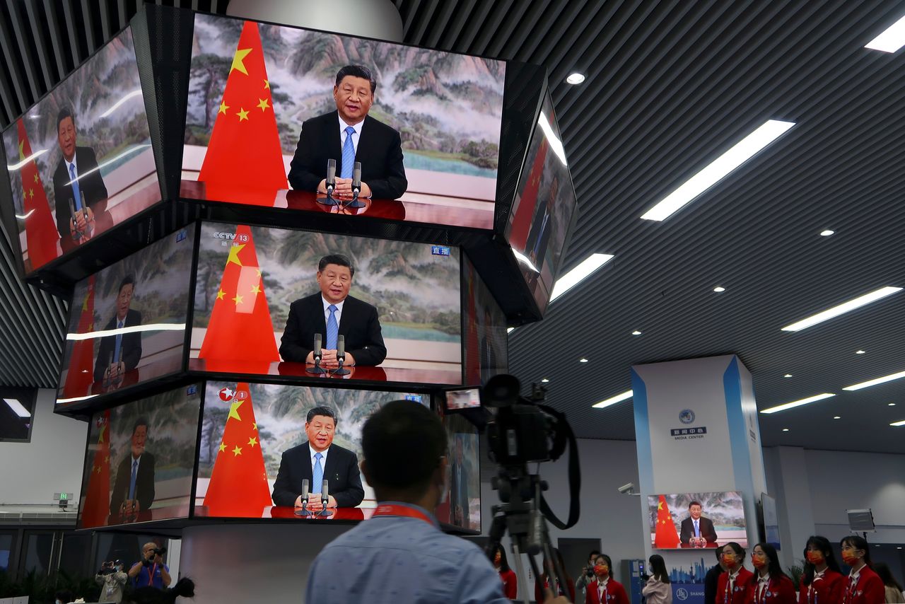 FILE PHOTO: Chinese President Xi Jinping is seen on television screens at a media centre as he delivers a speech via video at the opening ceremony of the China International Import Expo (CIIE) in Shanghai, China November 4, 2021. REUTERS/Andrew Galbraith/File Photo