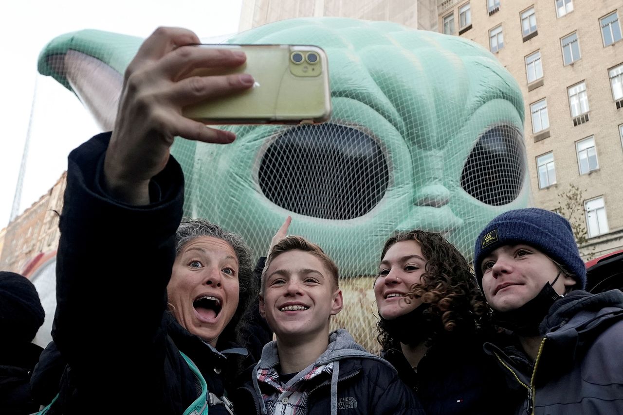 Transeúntes se toman selfie con globo de Baby Yoda en el desfile de Acción de Gracias de Macy
