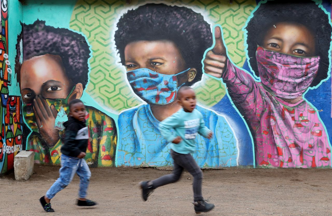 FOTO DE ARCHIVO: Niños pasan frente a un mural de Senzart911 en Sudáfrica, 27 de octubre del 2021. REUTERS/Siphiwe Sibeko