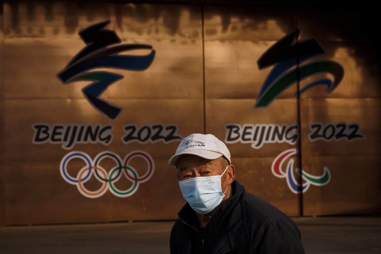 Un hombre con mascarilla pasa delante de dos logotipos de los Juegos Olímpicos de Invierno de Pekín 2022 en Pekín, China, el 8 de diciembre de 2021. REUTERS/Thomas Peter