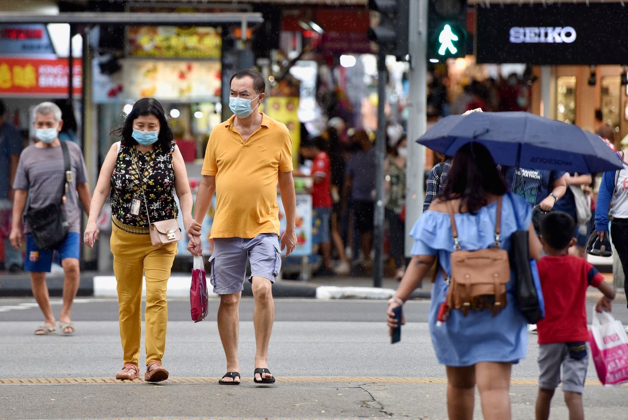 FOTO DE ARCHIVO: Personas con mascarilla cruzan una calle en Singapur, el 3 de noviembre de 2021. REUTERS/Caroline Chia
