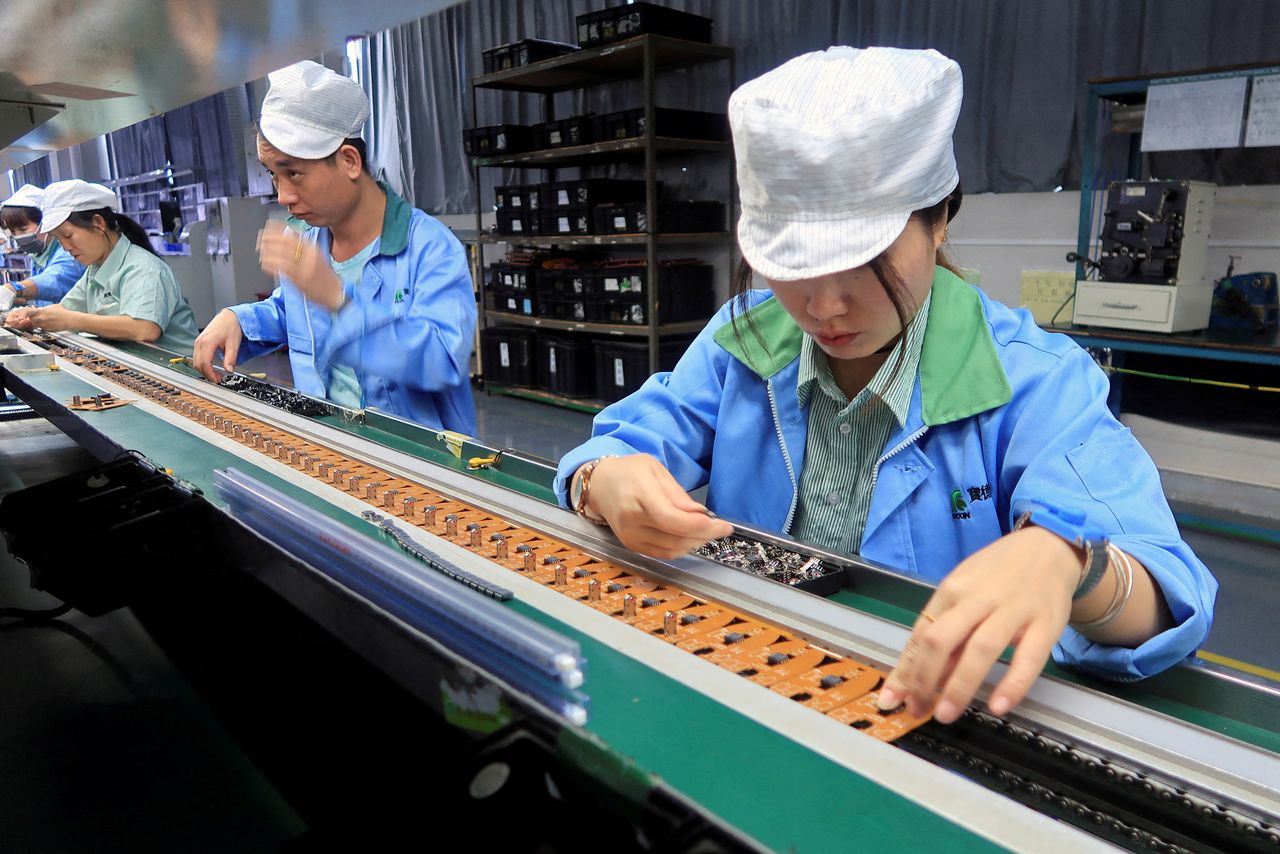 FOTO DE ARCHIVO: Línea de producción de controladores de juegos móviles para la empresa estadounidense T2M, en una fábrica en Dongguan, provincia de Guangdong, China, 7 de diciembre de 2021. REUTERS/David Kirton