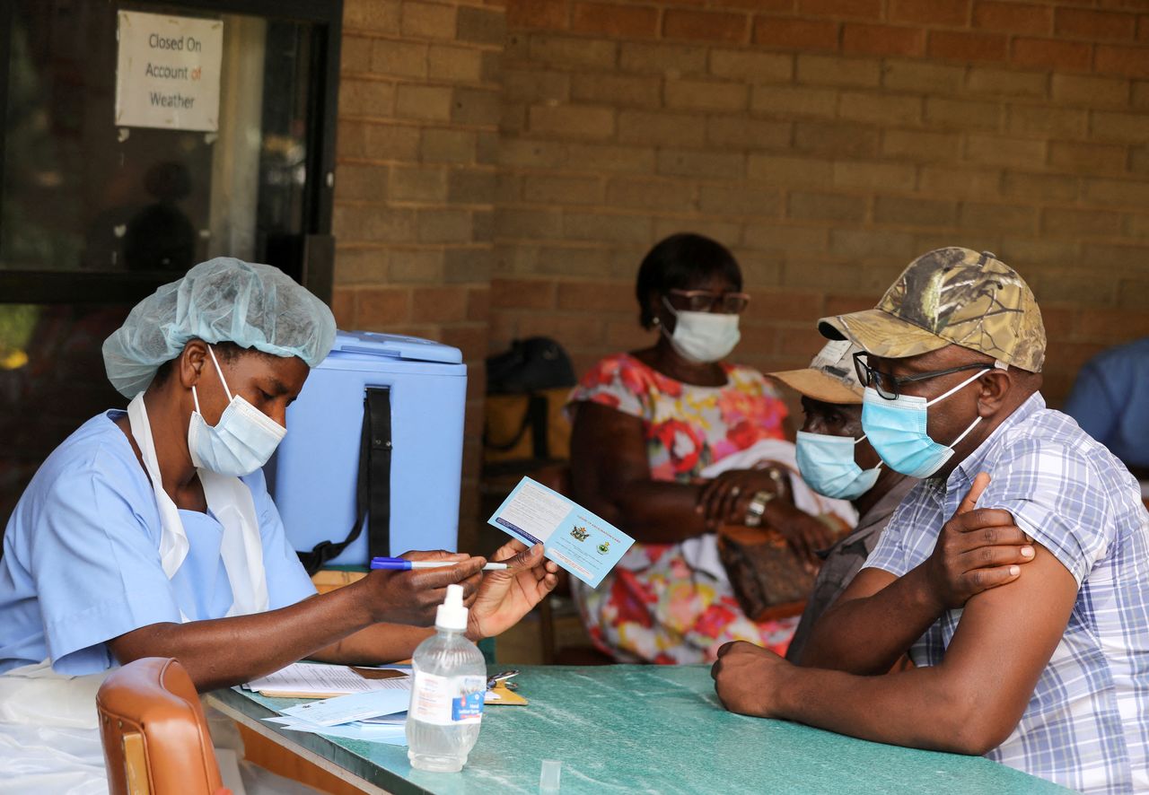 FOTO DE ARCHIVO: Un hombre recibe un certificado de vacunación tras recibir una dosis de la vacuna contra el COVID-19 en el Hospital Wilkins de Harare, Zimbabue, el 24 de marzo de 2021. REUTERS/Philimon Bulawayo