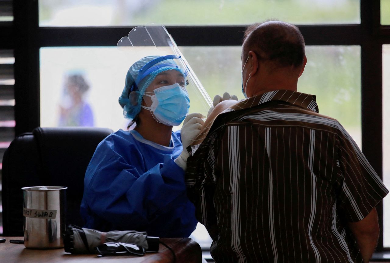 FOTO DE ARCHIVO: Una trabajadora sanitaria administra una dosis de la vacuna de COVID-19 a un hombre en Katmandú, China, el 6 de julio de 2021. REUTERS/Navesh Chitrakar