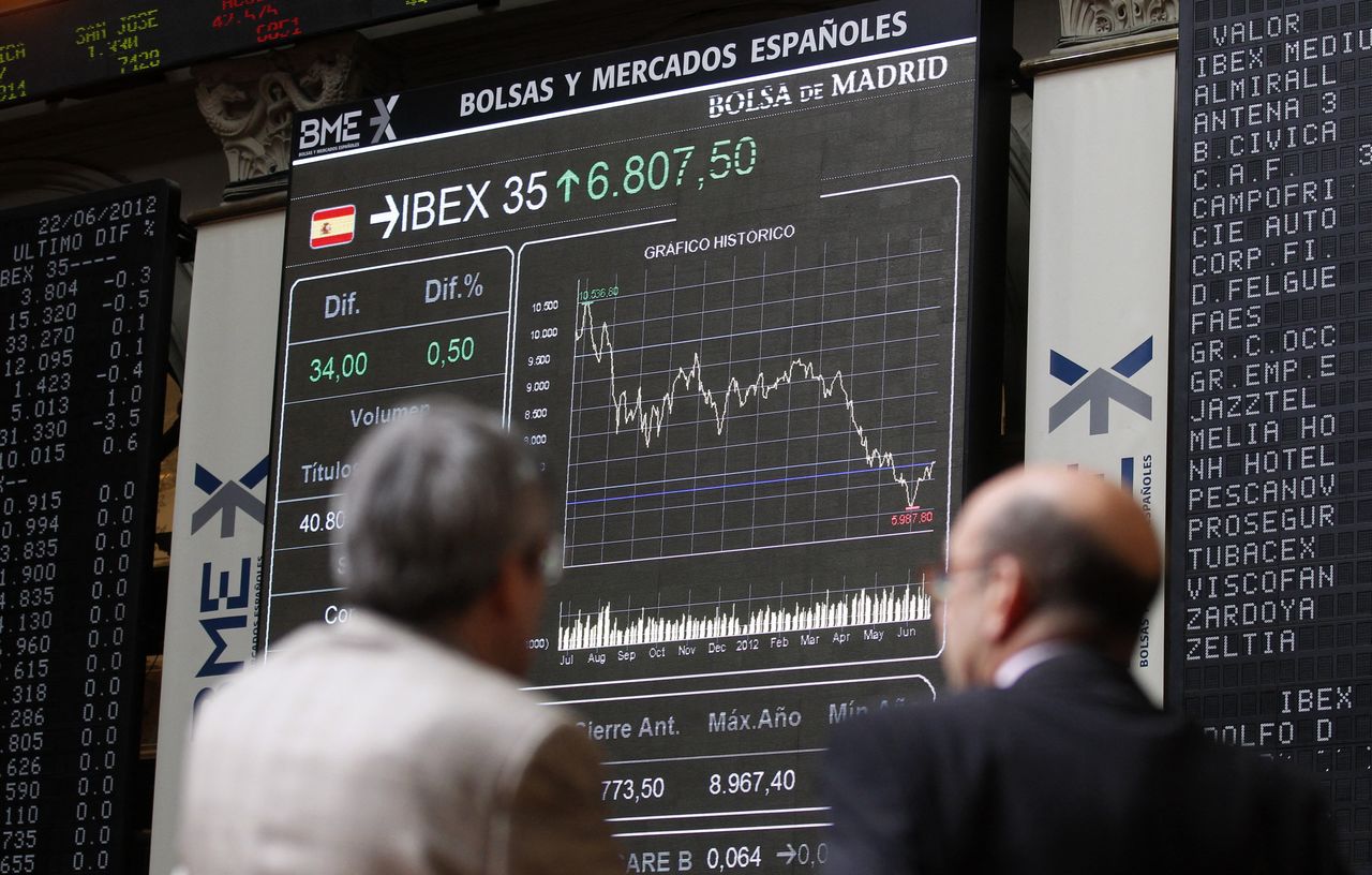 FOTO DE ARCHIVO: Dos hombres observan un panel con datos de cotización en el interior de la Bolsa de Madrid, España, el 22 de junio de 2012. REUTERS/Andrea Comas