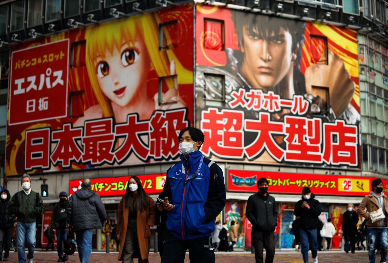 People wearing protective face masks walk on the street, amid the coronavirus disease (COVID-19) pandemic, in Tokyo, Japan January 19, 2022. REUTERS/Issei Kato
