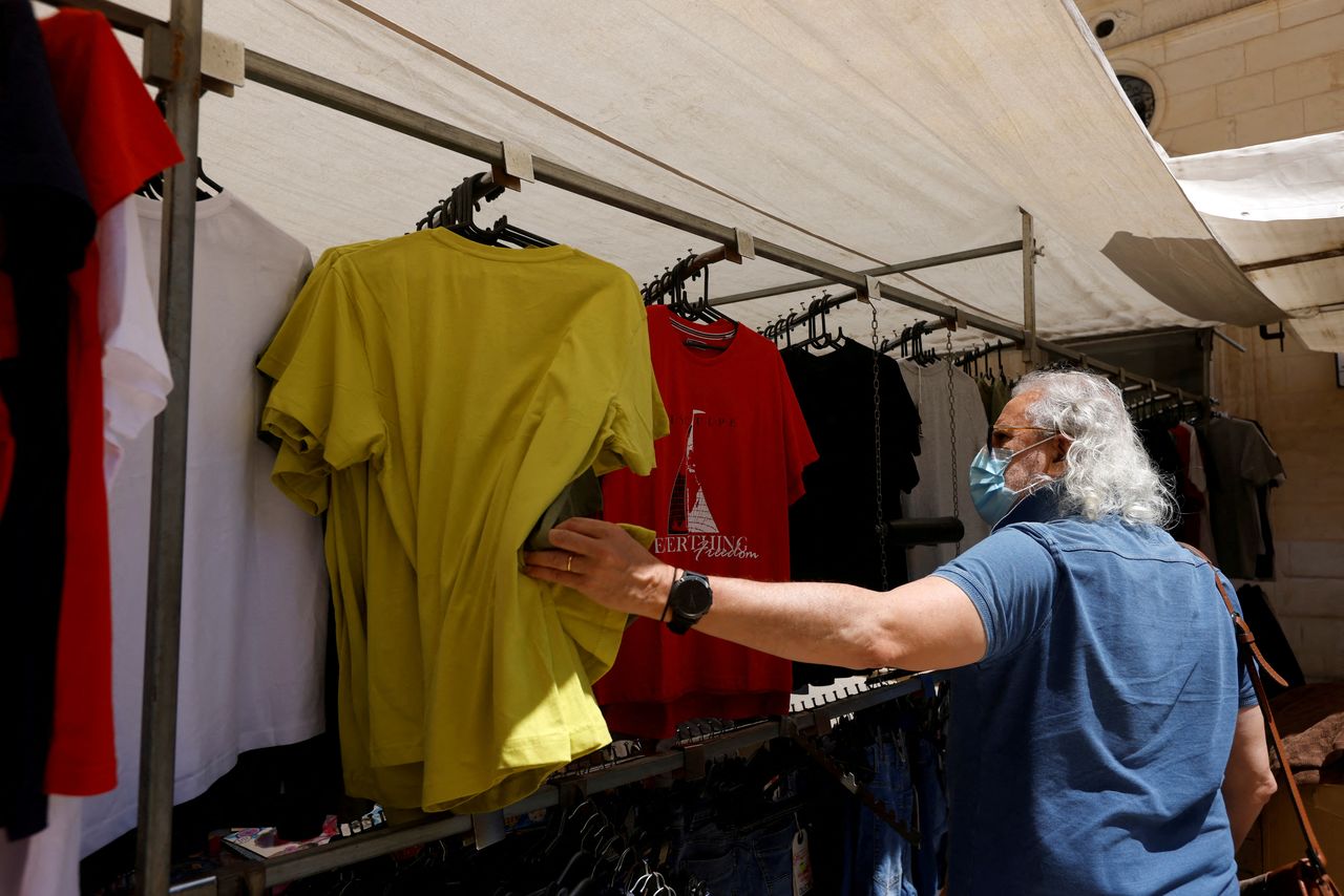 FOTO DE ARCHIVO: Un hombre con mascarilla mira camisetas en un mercadillo de La Valeta, Malta, el 10 de mayo de 2021. REUTERS/Darrin Zammit Lupi