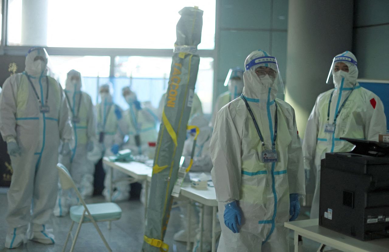 Miembros del personal con equipo de protección personal (EPP) diseñado para prevenir la propagación de la enfermedad del coronavirus (COVID-19), esperan a los pasajeros en el Aeropuerto Internacional de Pekín Capital antes de los Juegos Olímpicos de Invierno de Pekín 2022, en Pekín, China, 31 de enero de 2022. REUTERS/Hannah McKay