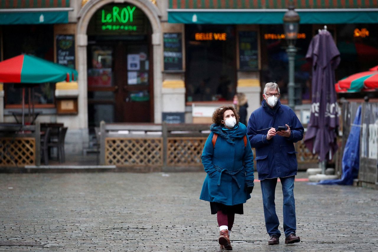 FOTO DE ARCHIVO: Dos personas con mascarilla caminan por la Grand-Place de Bruselas, Bélgica, el 21 de enero de 2022. REUTERS/ Johanna Geron