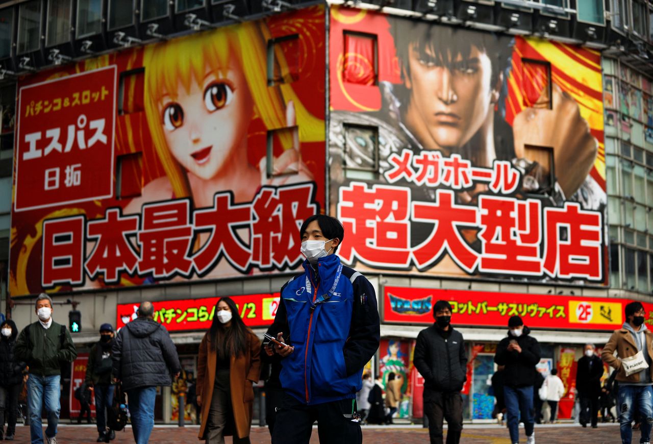 People wearing protective face masks walk on the street, amid the coronavirus disease (COVID-19) pandemic, in Tokyo, Japan January 19, 2022. REUTERS/Issei Kato