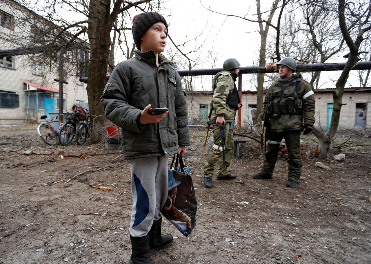 Un niño frente a un edificio de apartamentos, que según los lugareños fue dañado por los recientes bombardeos, en la ciudad de Yasynuvata (Yasinovataya), controlada por los separatistas, en la región de Donetsk, Ucrania, el 24 de febrero de 2022. REUTERS/Alexander Ermochenko