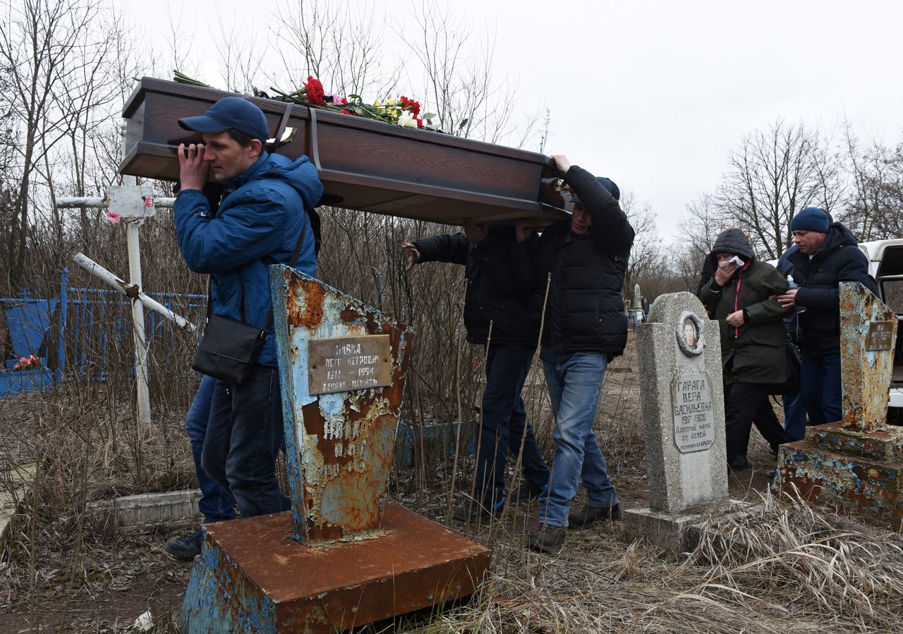 Hombres llevan el féretro durante el funeral de las maestras de escuela Yelena Ivanova y Yelena Kudrik, que murieron por bombardeo, en un cementerio de la ciudad de Górlovka, controlada por los separatistas, en la región de Donetsk, Ucrania. 28 de febrero de 2022. REUTERS/Stringer