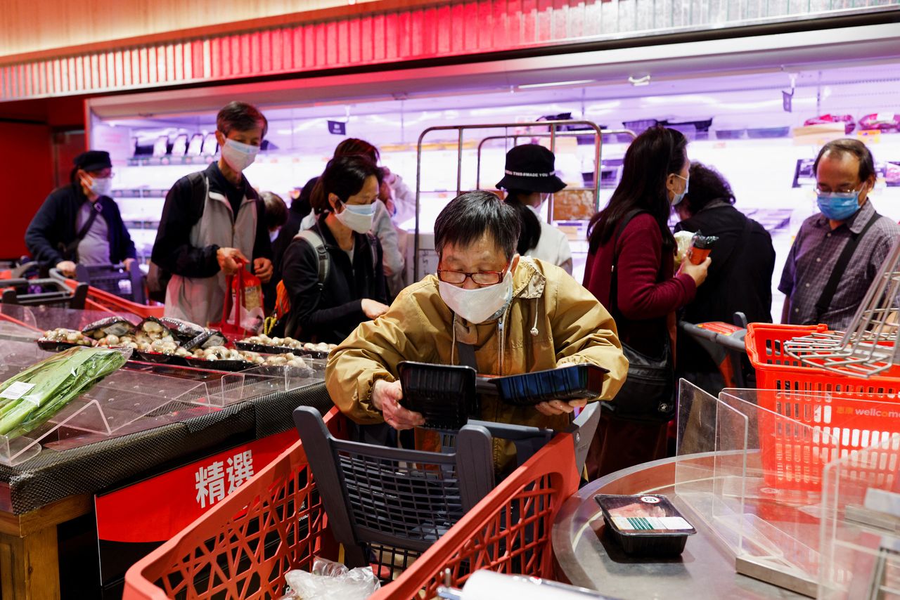 Un cliente con mascarilla compra carne fresca en un supermercado en Hong Kong, China, 1 de marzo de 2022. REUTERS/Tyrone Siu
