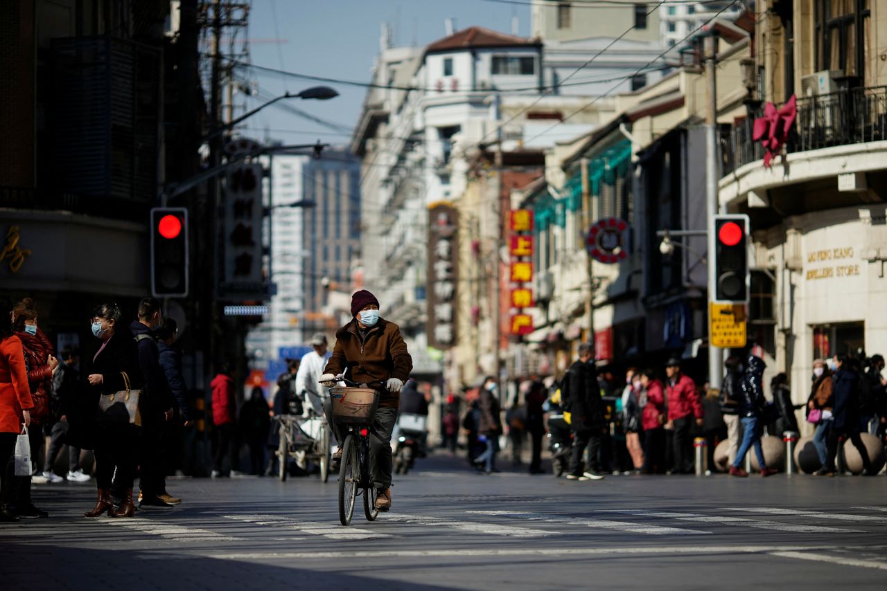 FOTO DE ARCHIVO: Un hombre con mascarilla circula en bicicleta por una calle de Shanghái, China el 25 de febrero de 2022. REUTERS/Aly Song