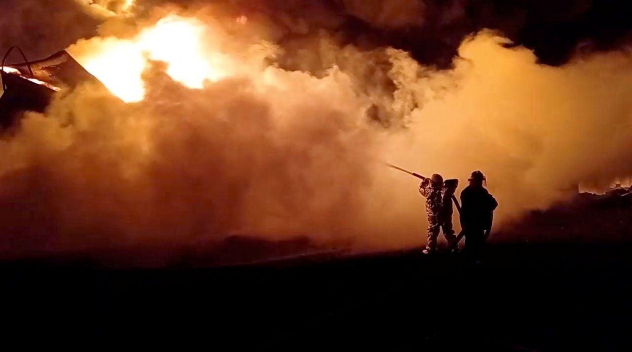 Un grupo de bomberos extingue un incendio en un depósito de petróleo en la región de Yitomir, Ucrania. 7 de marzo de 2022. Imagen obtenida de un vídeo facilitado a Reuters. Servicios de Emergencia Estatales de Ucrania/Handout vía REUTERS