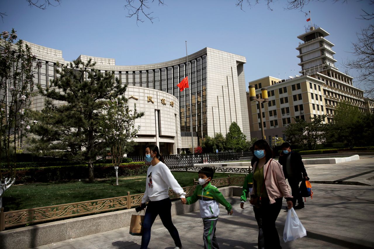 FOTO DE ARCHIVO: Personas con mascarilla pasan por delante de la sede del banco central chino Banco Popular de China (PBOC), 4 de abril de 2020. REUTERS/Tingshu Wang