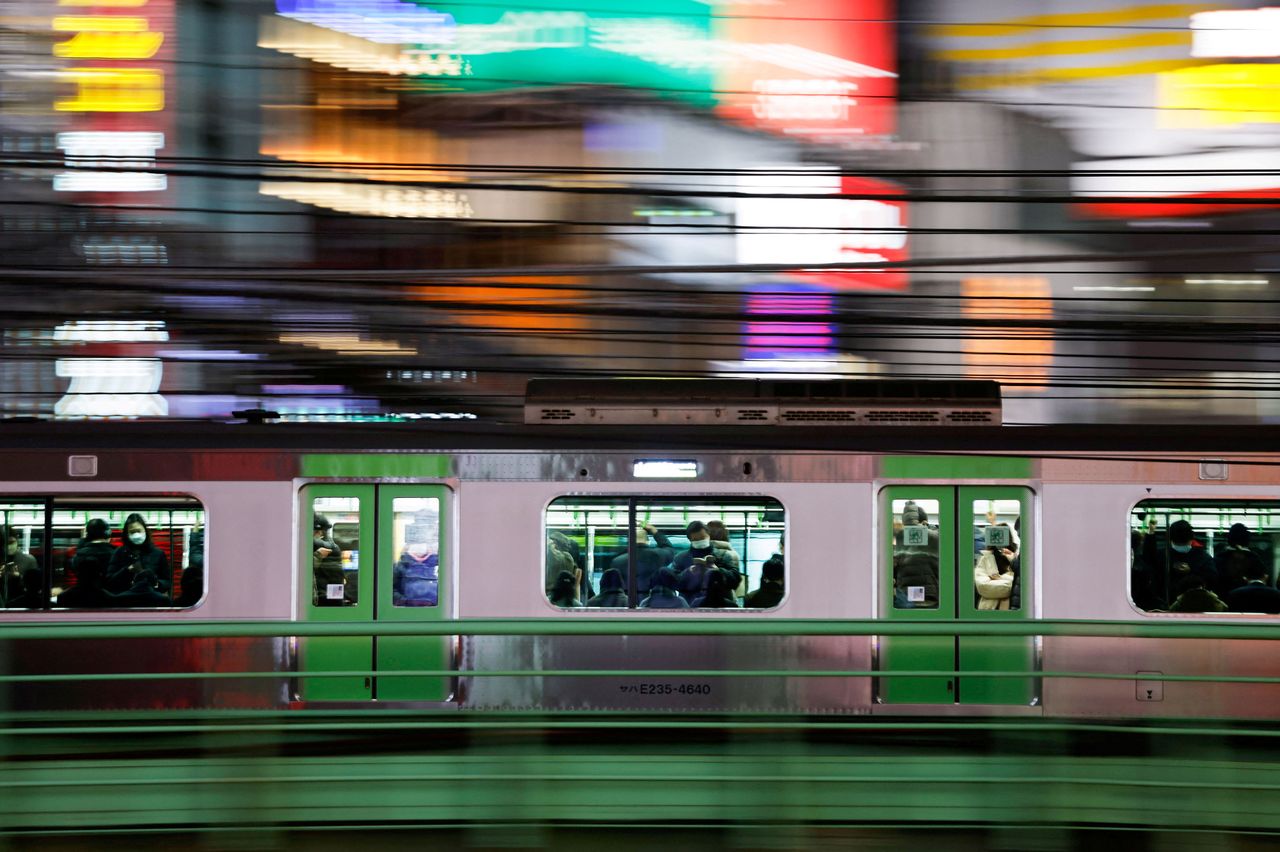 FOTO DE ARCHIVO: Pasajeros con mascarillas protectoras dentro de un tren, en medio de la pandemia de la enfermedad del coronavirus (COVID-19), en Tokio, Japón 9 de febrero de 2022. Imagen tomada con velocidad de obturación lenta. REUTERS/Issei Kato