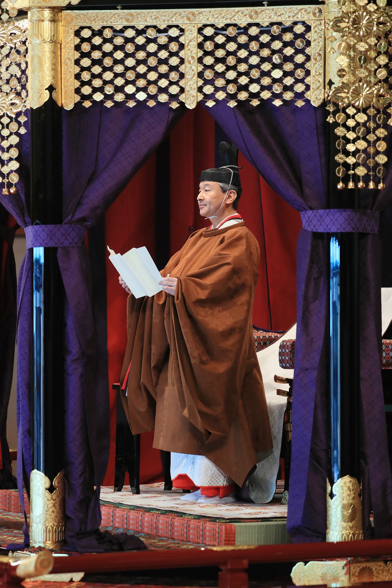 El Emperador procede a leer unas palabras desde el takamikura. (© Jiji)