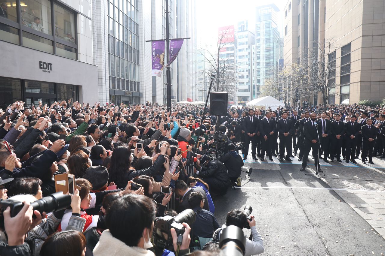 Michael Leitch (en el centro, a la derecha, encabezando el desfile), el capitán de la selección nipona, conduce al resto de miembros del equipo nacional de rugby durante el desfile celebrado el 11 de diciembre de 2019 en Tokio. (© Jiji)