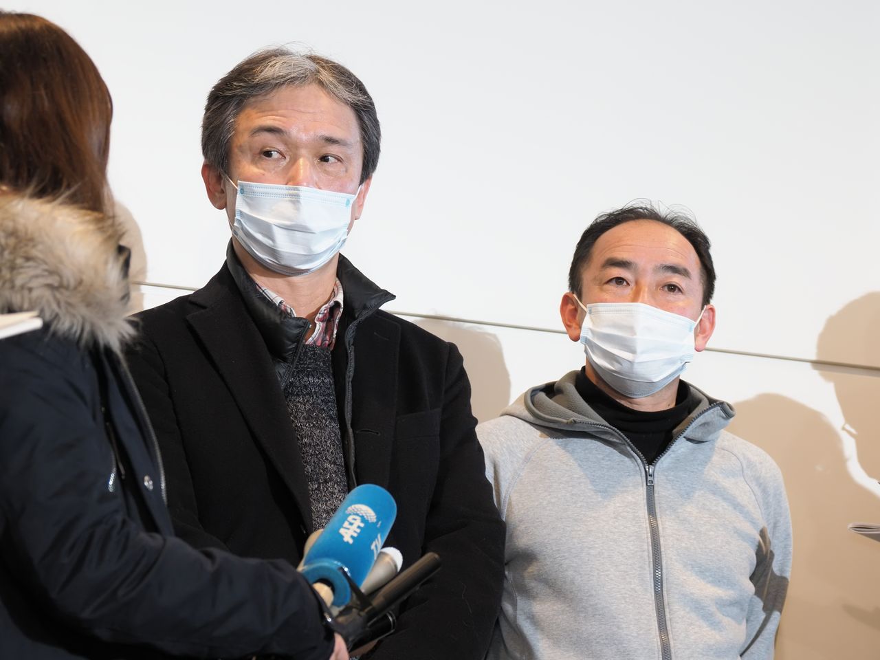 Varios ciudadanos japoneses trasladados de vuelta desde Wuhan hablan con la prensa en el aeropuerto de Haneda el 29 de enero de 2020. (© Jiji)