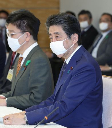 新型コロナウイルス感染症対策本部で発言する安倍晋三首相(右)=16日夜、首相官邸