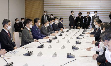 新型コロナウイルス感染症対策本部で発言する安倍晋三首相(左手前から3人目)=16日夜、首相官邸