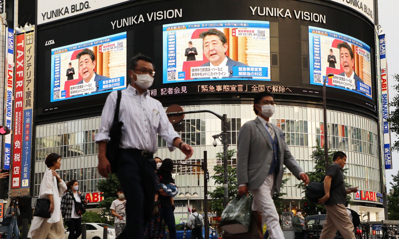 En varias pantallas en Shinjuku, Tokio, se informa sobre el levantamiento del estado de emergencia el 25 de mayo de 2020. (© Jiji)