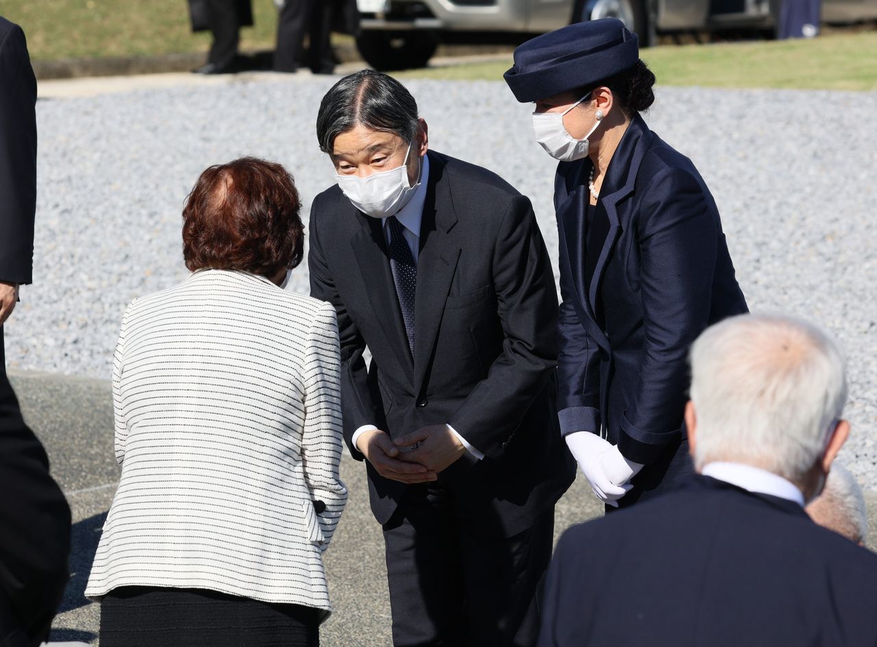 El emperador Naruhito, a la izquierda, y la emperatriz Masako hablan con un familiar de una víctima de la Batalla de Okinawa durante su visita al Parque Conmemorativo de la Paz en Itoman el 22 de octubre de 2022. (© Jiji)
