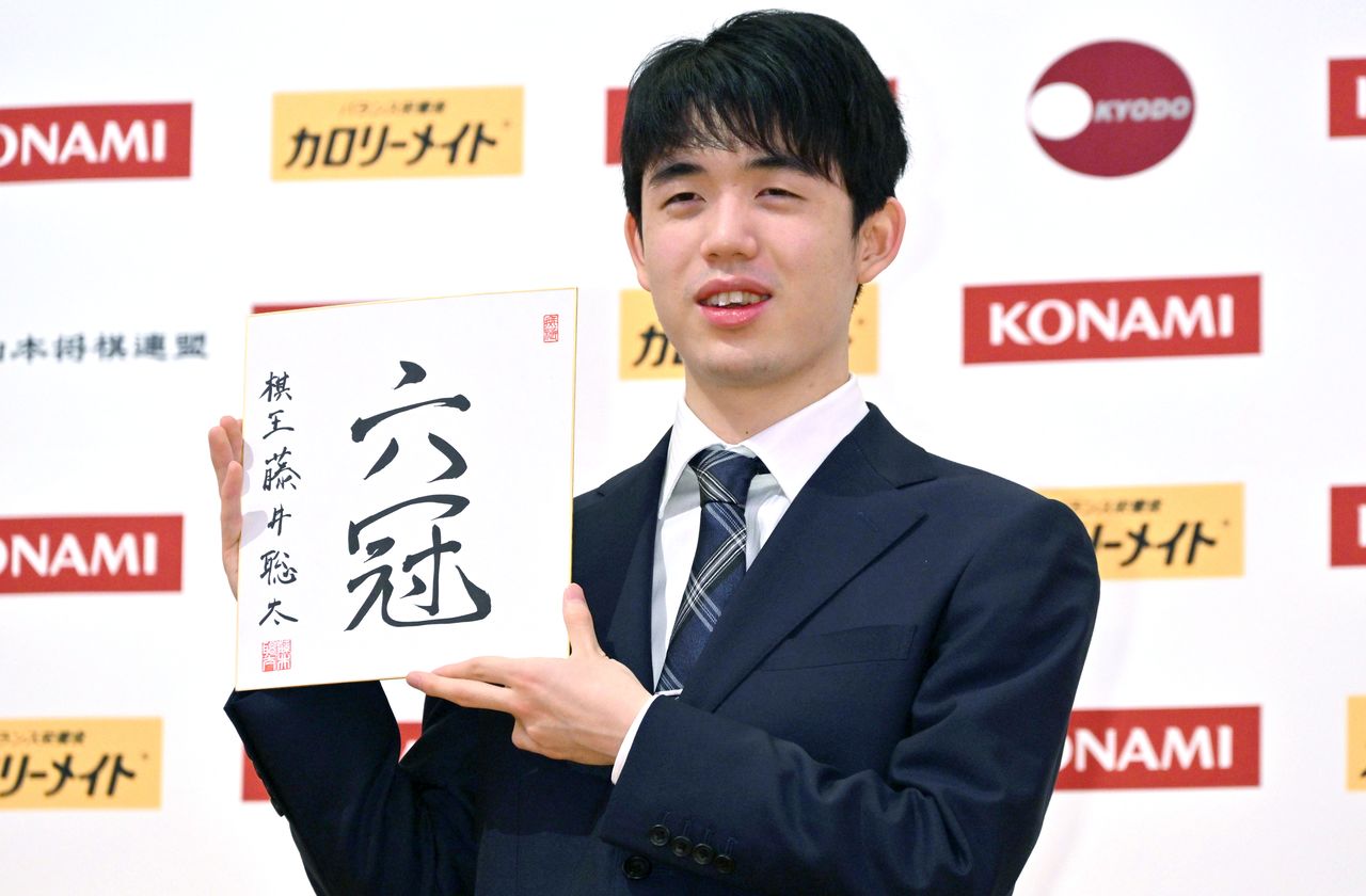 Fujii Sōta sostiene una caligrafía que conmemora su sexto título en Nikkō, en la prefectura de Tochigi, el 20 de marzo de 2023. (© Jiji)