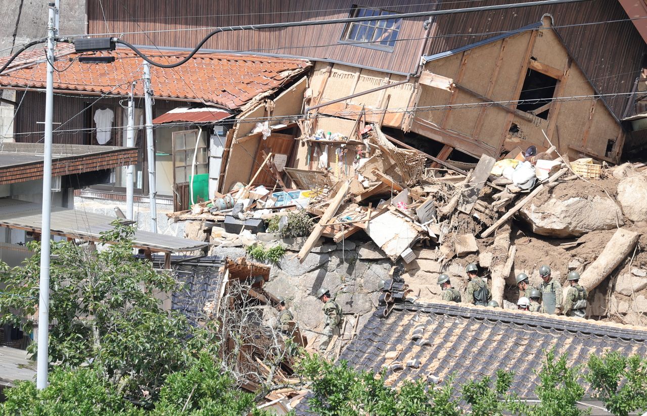 Miembros de las Fuerzas de Autodefensa realizan tareas de búsqueda entre los restos de unas casas destruidas por los escombros arrastrados por las lluvias torrenciales. Fotografía tomada en Karatsu, en la prefectura de Saga, el 11 de julio de 2023. (© Jiji)
