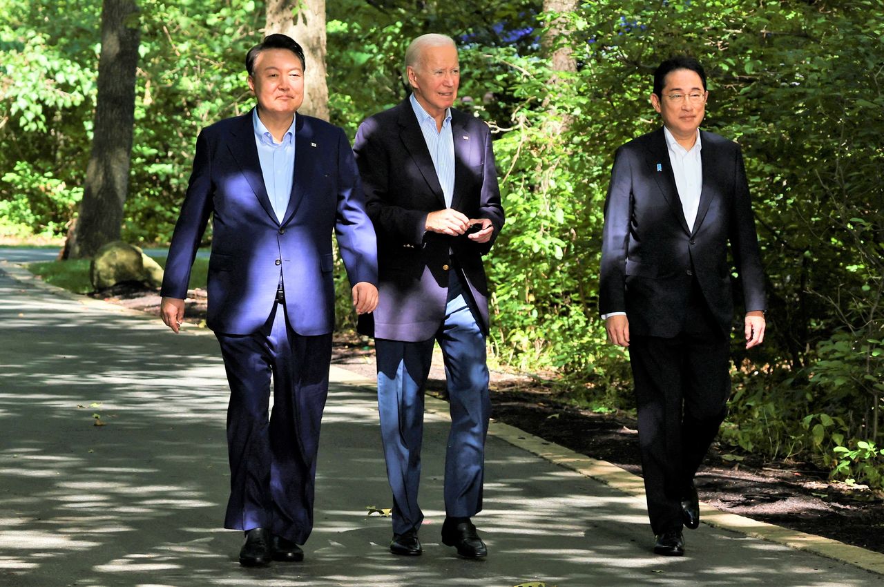 Desde la izquierda, Yoon Suk-yeol, Joe Biden y Kishida Fumio se dirigen al lugar en el que ofrecerán una rueda de prensa conjunta durante la cumbre trilateral en Camp David, cerca de Thurmont, Maryland, el 18 de agosto de 2023. (© Reuters)