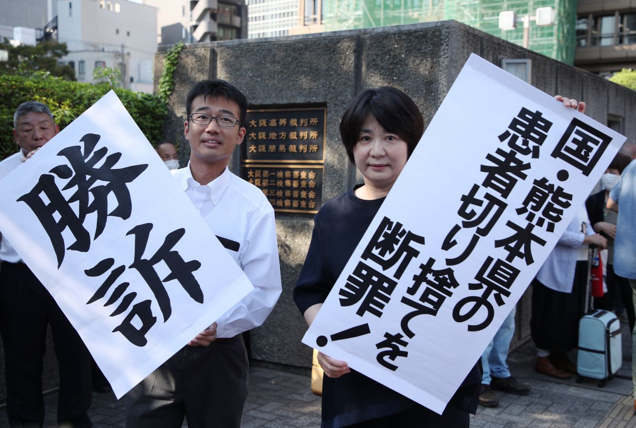Los abogados de los demandantes sujetan carteles que anuncian su victoria en el caso de la enfermedad de Minamata en un tribunal de Osaka el 27 de septiembre de 2023. (© Jiji)