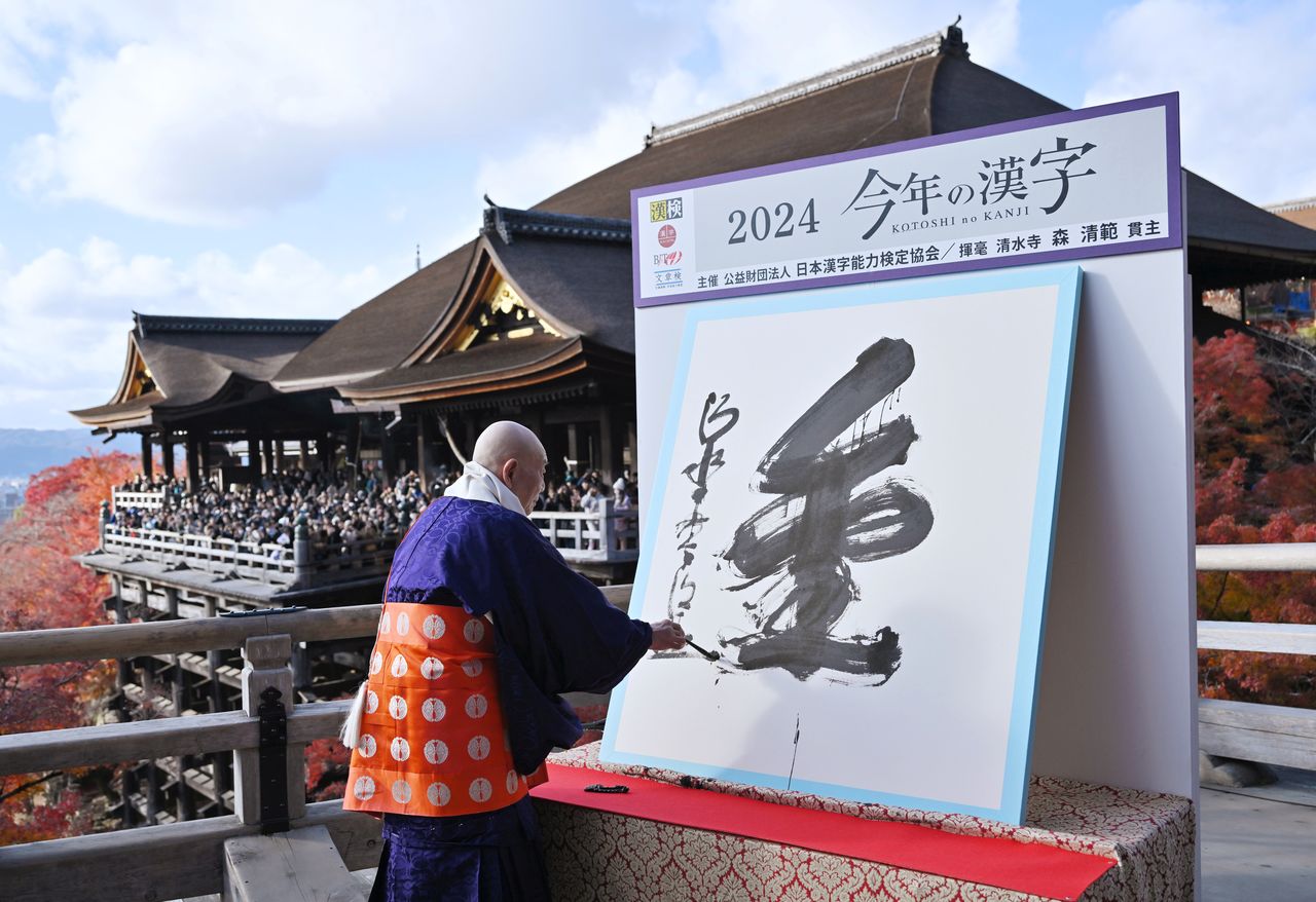 El sumo sacerdote del Kiyomizudera, Mori Seihan, escribe el Kanji del Año, “kin”, el 12 de diciembre de 2025 en el famoso templo de Kioto. (© Jiji)
