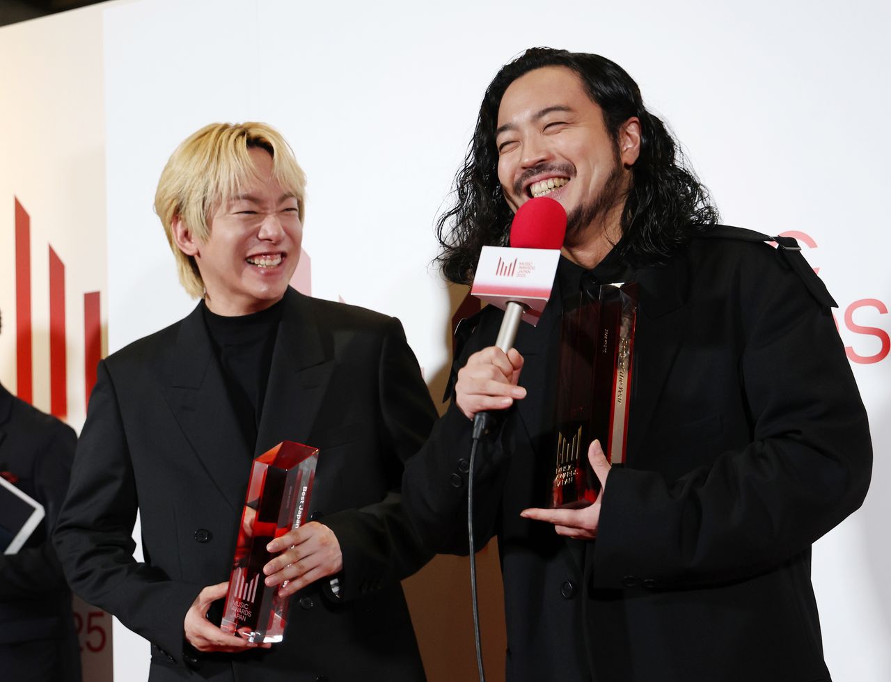 Los miembros de Creepy Nuts sonrientes después de ganar el premio a la Canción del Año en el Teatro Rohm de Kioto, el 22 de mayo de 2025. (© Jiji)