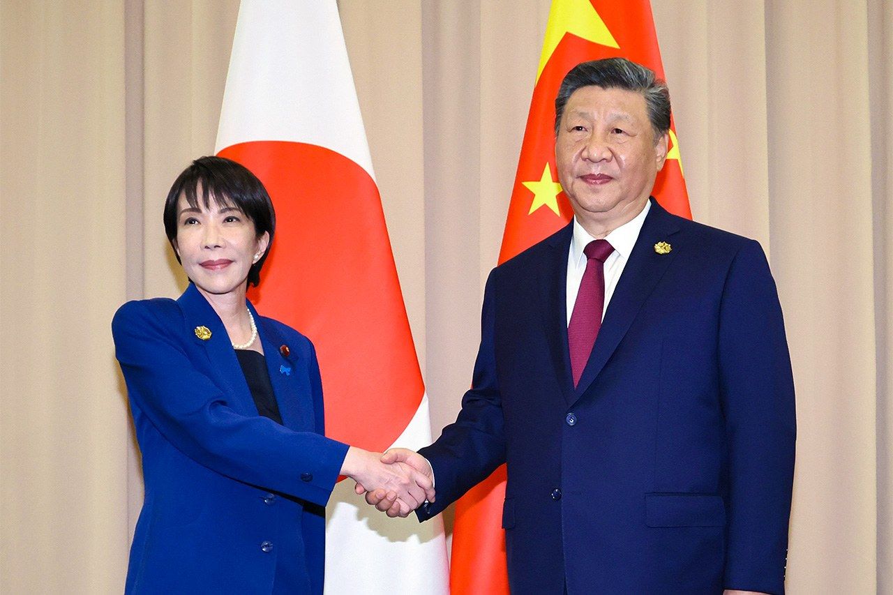 El presidente Xi Jinping (a la derecha) estrecha la mano de la primera ministra Takaichi en Gyeongju, Corea del Sur. (© Jiji)