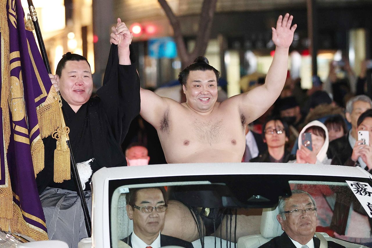 Kirishima, en el centro, con los brazos alzados en su desfile de la victoria en Osaka el 22 de marzo de 2026. (© Jiji)