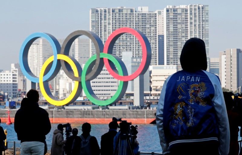 FOTO DE ARCHIVO: Transeúntes observan cómo los anillos olímpicos gigantes son reinstalados en el área de la costa en el Parque Marino de Odaiba en Tokio, Japón, el 1 de diciembre de 2020. REUTERS/Kim Kyung-Hoon