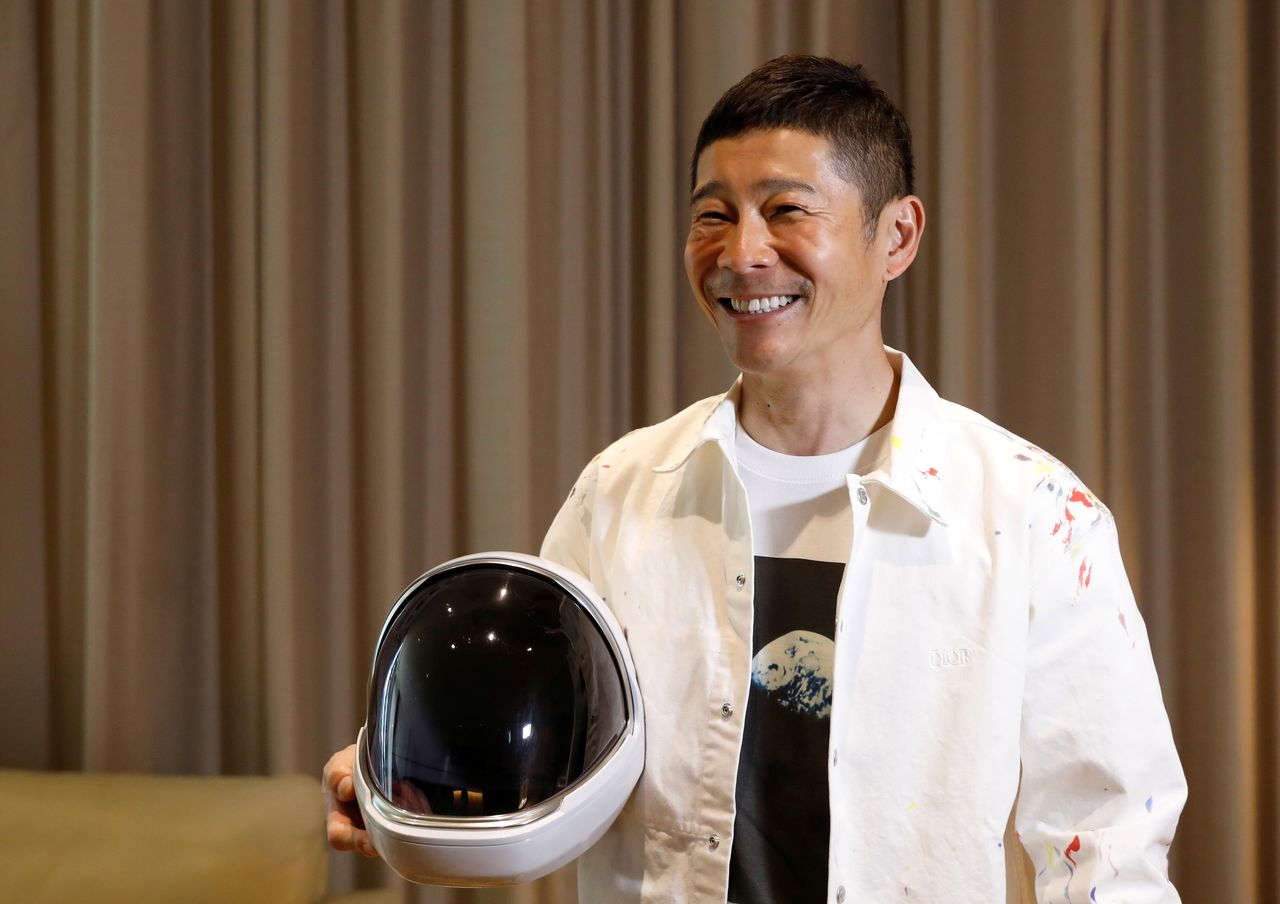 El multimillonario japonés Maezawa Yūsaku posa con el casco de un traje espacial durante una entrevista con Reuters en Tokio, Japón, el 3 de marzo de 2021. REUTERS/Kim Kyung-Hoon