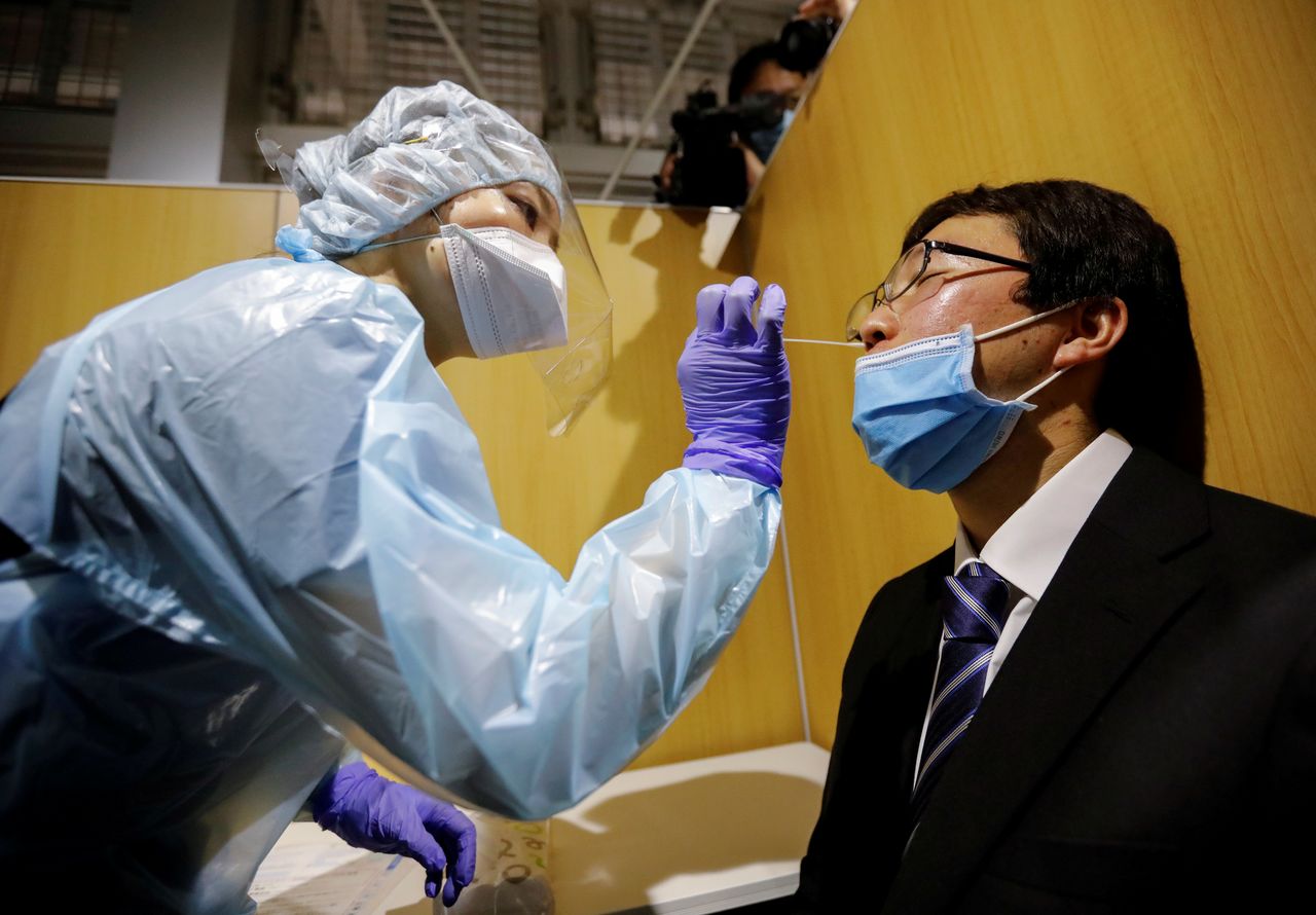 FOTO DE ARCHIVO: Un trabajador de la sanidad con protección realiza un simulacro de un test de reacción en cadena de la polimerasa (PCR) en un nuevo centro de PCR abierto en el Aeropuerto Internacional de Narita, en Narita al este de Tokio el 2 de noviembre de 2020. REUTERS/Issei Kato/File Photo