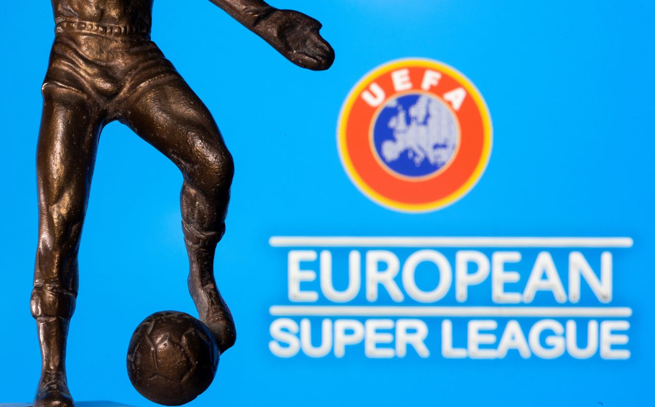 Una figura metálica de un jugador de fútbol con un balón se ve delante de las palabras "Superliga Europea" y el logotipo de la UEFA en esta ilustración tomada el 20 de abril de 2021. REUTERS/Dado Ruvic