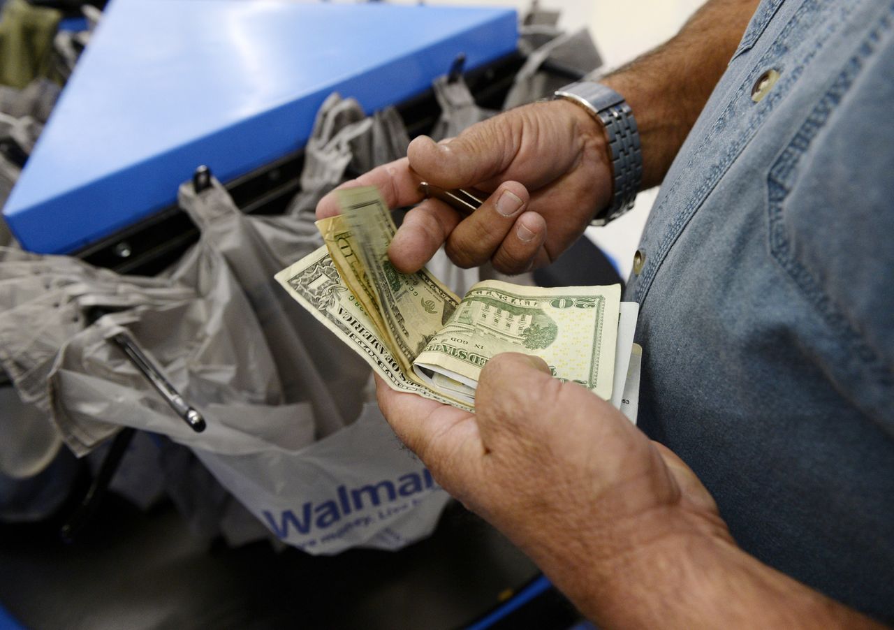 Imagen de archivo de un cliente contando dólares en un supermercado Walmart de Los Ángeles, EEUU. 26 noviembre 2013. REUTERS/Kevork Djansezian